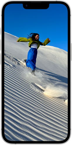 Lidé jdoucí po písečné duně na Super Retina XDR displeji Phonu 16e