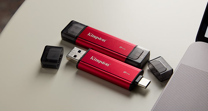 Duální přenosný SSD disk na stolním počítači s konektory USB Type-A a Type-C položenými vedle notebooku a telefonu