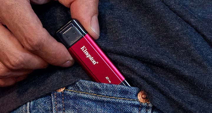 The Dual Portable SSD is being placed in a small receptacle, such as a pocket or bag