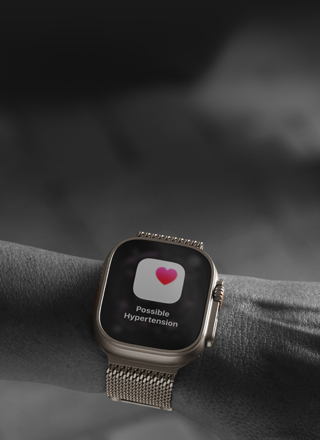 Osoba s Apple Watch Ultra 3 na zápěstí, obrazovka se zdravotním upozorněním na možnou hypertenzi